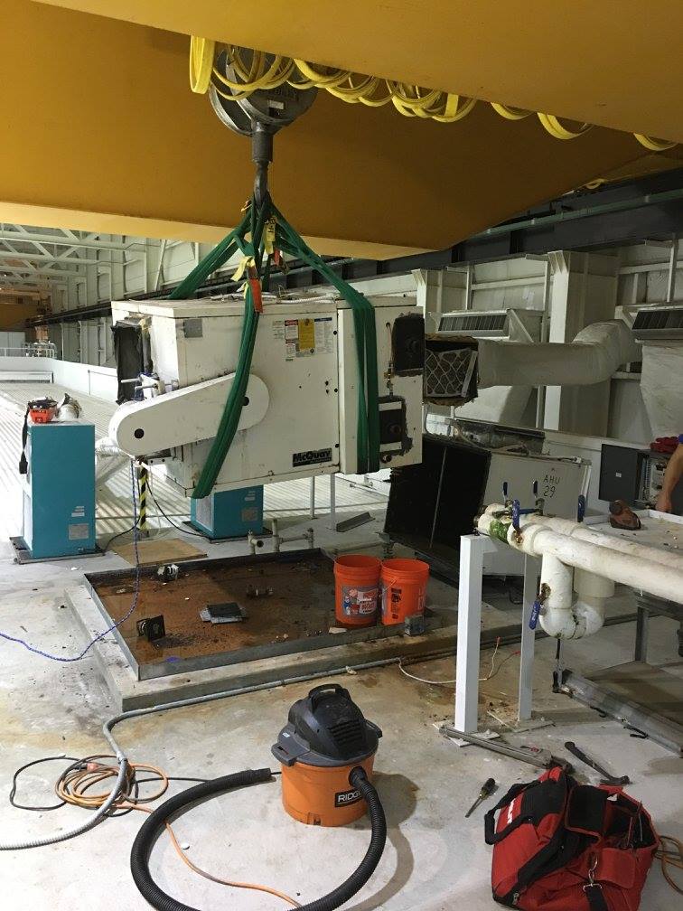 McQuay air handler being lifted out using the overhead bridge crane and rigging slings